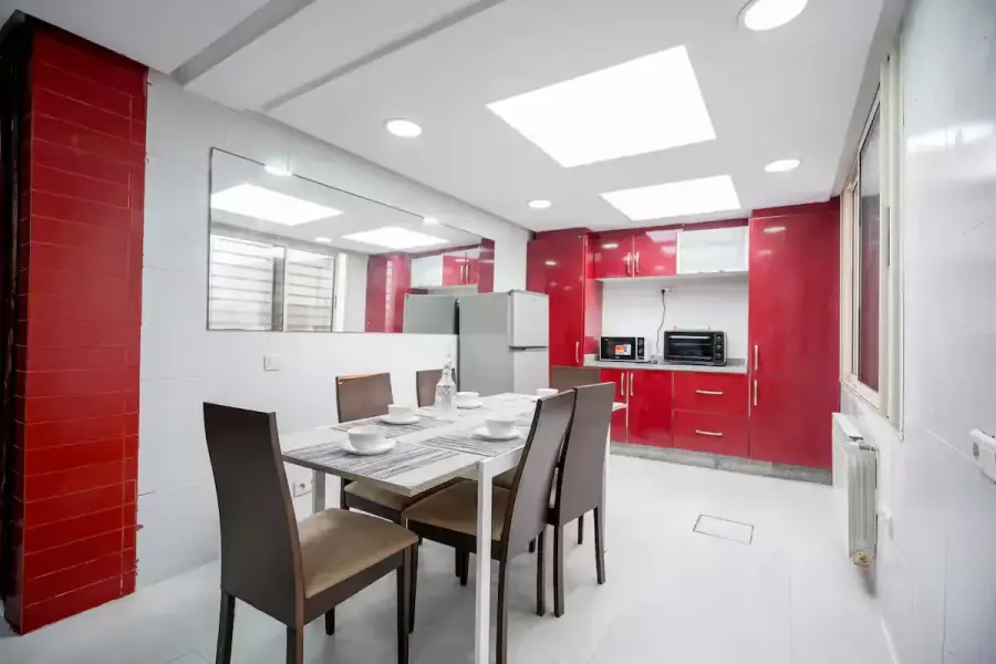 Cuisine moderne rouge et salle à manger d’une villa de luxe