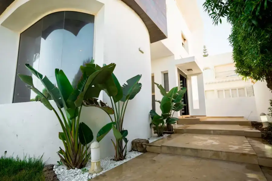Entrée extérieure végétalisée d’une villa contemporaine