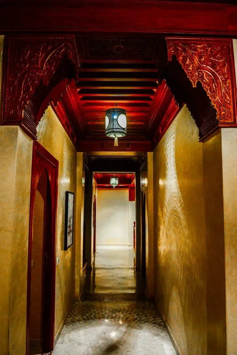 Couloir traditionnel marocain aux boiseries sculptées, Quattrocento Palace, riad de luxe à Marrakech