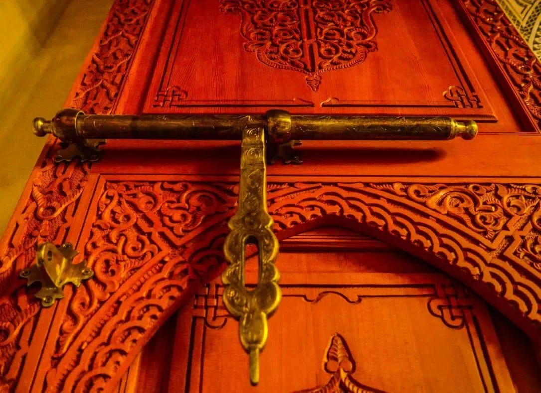 Porte en bois sculptée à la marocaine avec poignée en laiton, Quattrocento Palace Marrakech