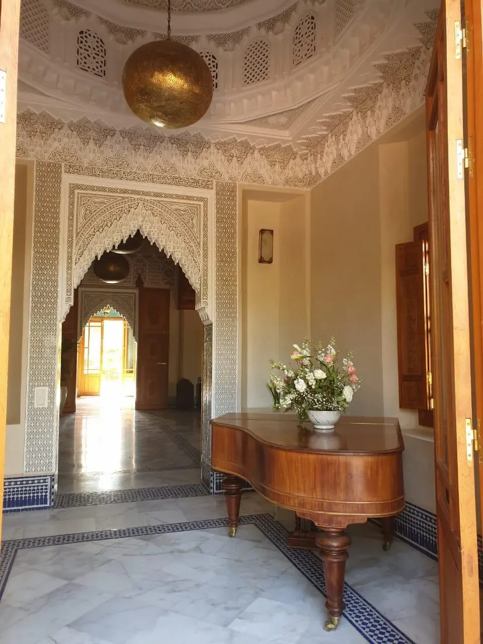 Hall d'entrée orné d'une arche marocaine et d'un piano, Quattrocento Palace, riad de luxe à Marrakech