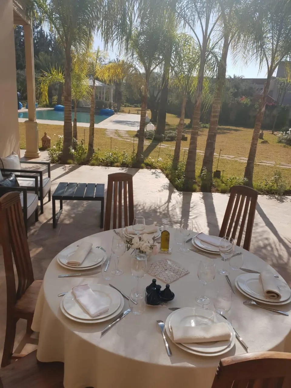 Table dressée en terrasse avec vue sur piscine et jardin de palmiers, Quattrocento Palace Marrakech