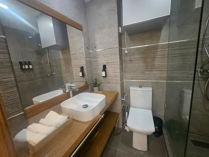 Modern tiled bathroom with vessel sink vanity and walk-in shower at Ciel Studio