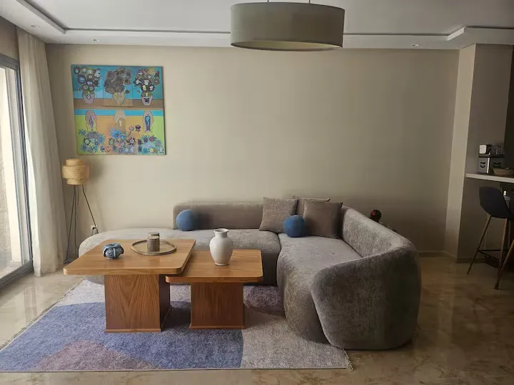 Luxury living room space in Ciel Studio with curved sofa and wooden coffee tables