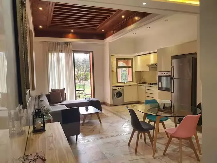 Open-plan living room, dining area, and American kitchen in an apartment with pool in Marrakech