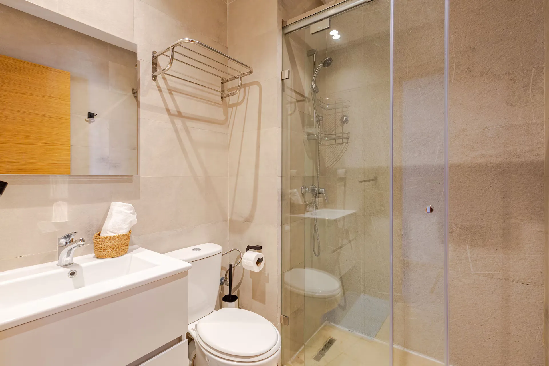 Second fully renovated bathroom with enclosed glass shower in a palm grove apartment