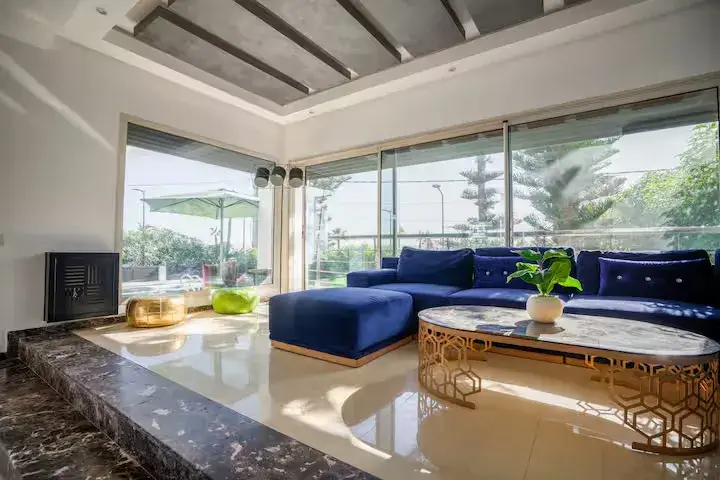 Salon raffiné avec canapé bleu et vue sur la piscine