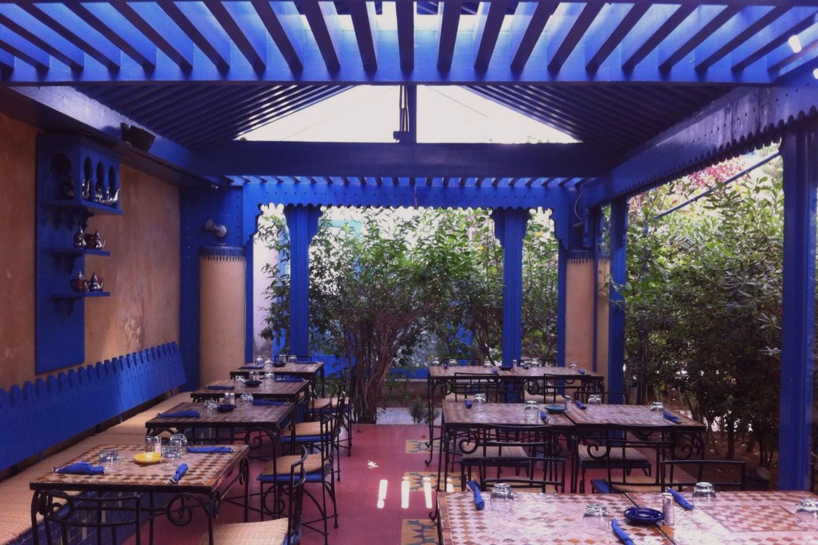 Vibrant blue shaded patio seating area at la sqala Café in Casablanca Morocco