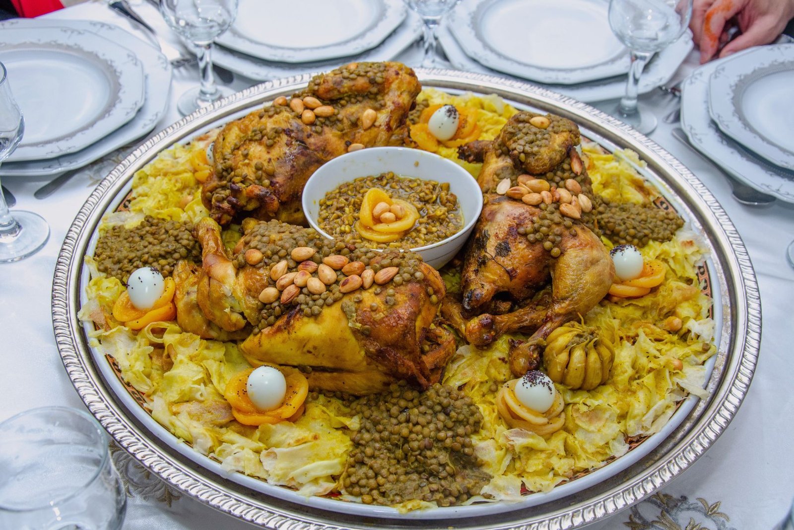 Large platter of traditional Moroccan rfissa with roasted chicken, lentils, and shredded flatbread