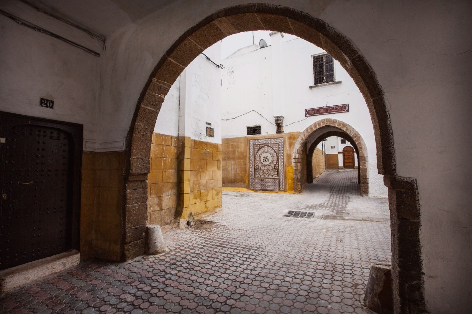 Passages sous arches en pierre et ruelles blanchies à la chaux dans le quartier habous de Casablanca