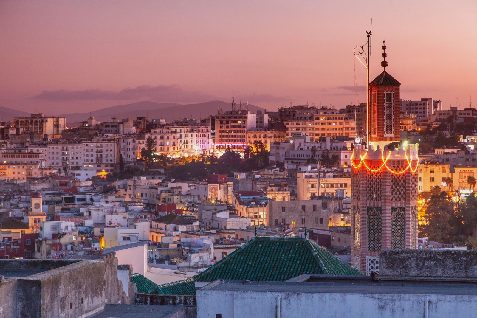 Minaret illuminé surplombant le panorama urbain au coucher du soleil à Tanger au Maroc