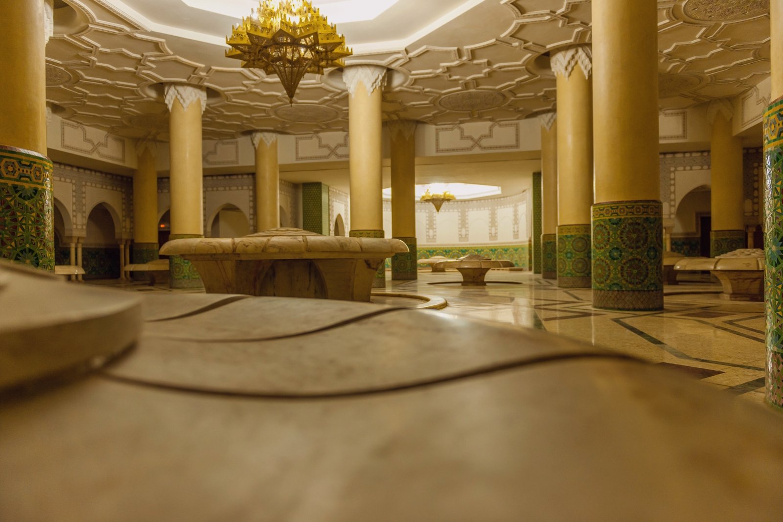 Intérieur luxueux d'un hammam traditionnel marocain avec colonnes et mosaïques en zellige