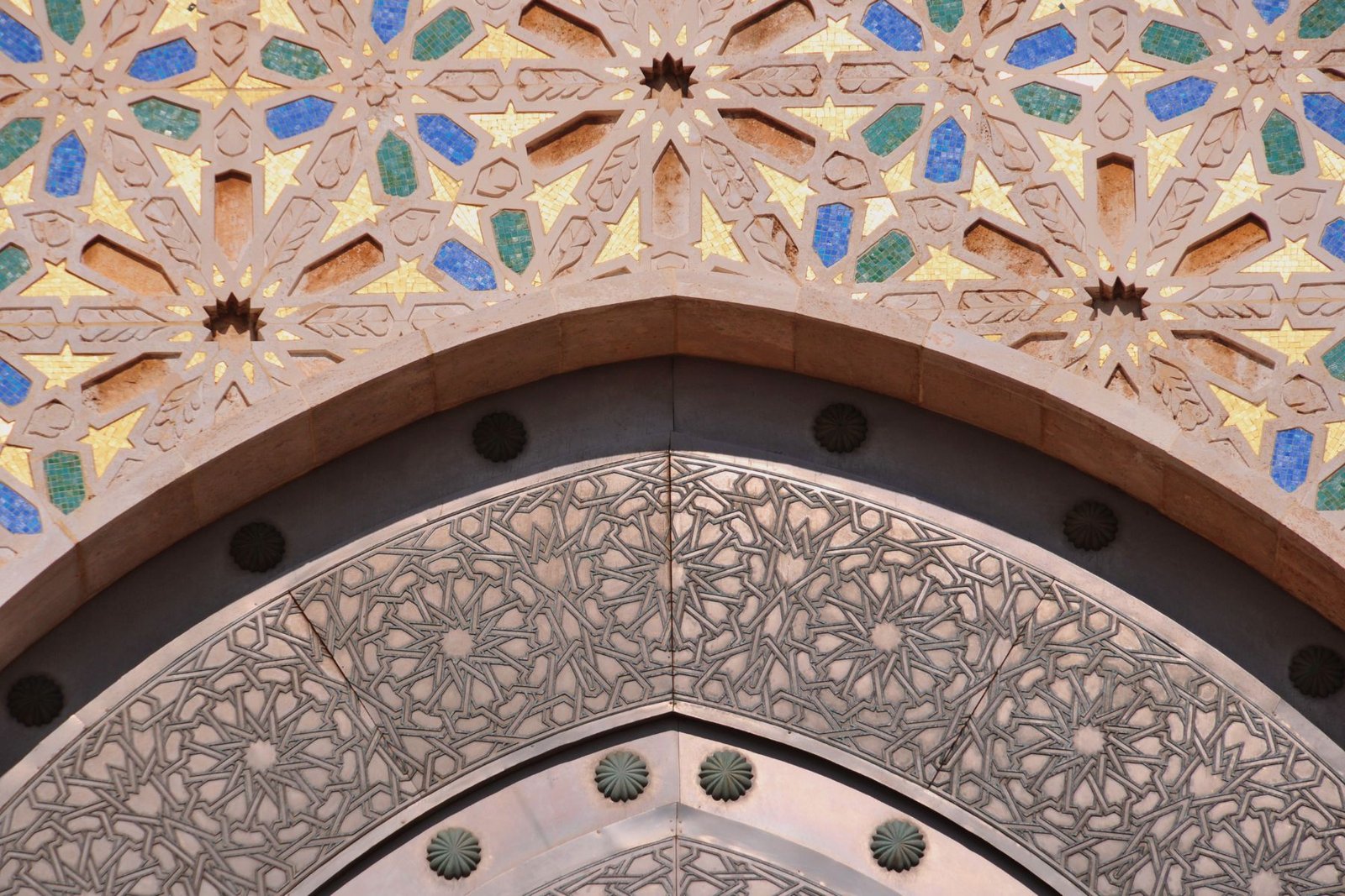 Detailed geometric pattern of handcrafted Moroccan zellige tilework on an archway