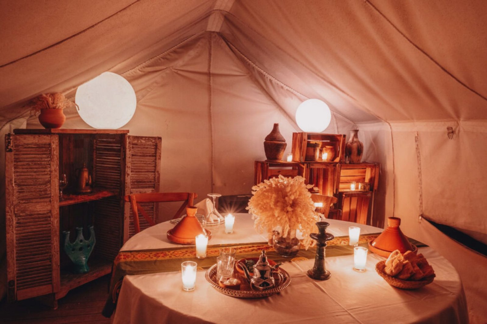 Cozy candlelit dining setup inside a luxury agafay marrakech desert camp tent