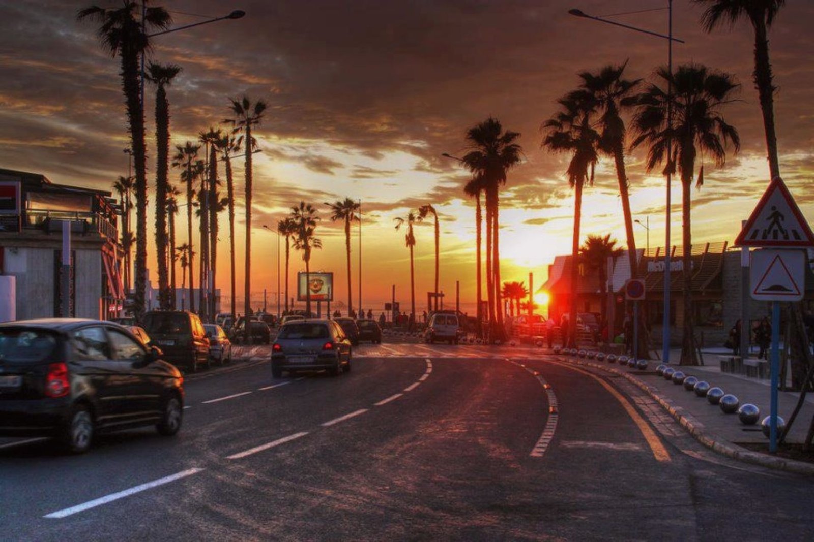 Boulevard de la Corniche bordé de palmiers au coucher du soleil à Casablanca
